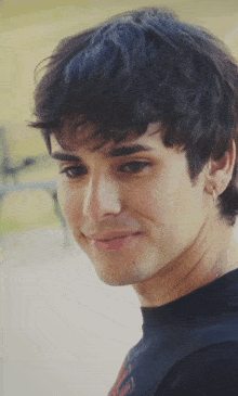 a close up of a young man 's face with a smile