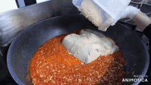 a person is pouring something into a pan that says made in animotica on the bottom