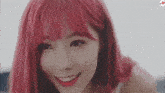 a close up of a woman with red hair and red lipstick smiling .