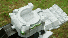a white toy with a green stripe on the bottom is sitting on the grass