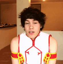 a young man wearing a white shirt with a red and yellow triangle on the front