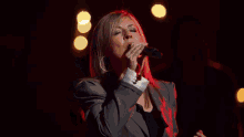 a man is playing a keyboard in front of a microphone