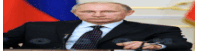 a man in a suit and tie is sitting at a table in front of a russian flag .