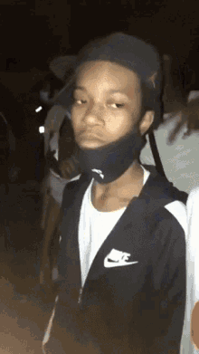 a man wearing a nike jacket and a mask