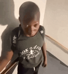 a young boy wearing a shirt that says ok captain on it