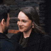 a man kisses a woman on the cheek and she is smiling