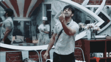 a man in a white shirt is dancing in front of a mirror with the letter g on it