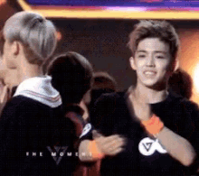 a man wearing a black shirt with a white v on it is hugging another man .