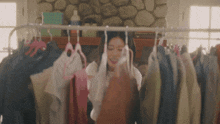 a woman looks through a rack of clothes