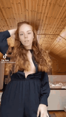 a woman in a black dress has a tiktok sticker on her face
