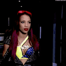 a woman with red hair is standing in front of a green exit sign