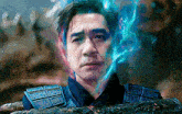 a close up of a man 's face with blue flames coming out of his head