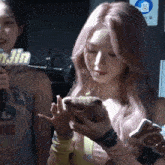 a girl with pink hair is holding a small animal in her hands with a sign that says jin in the background