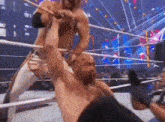 two men are wrestling in a ring and one of them is chained to the other 's neck .