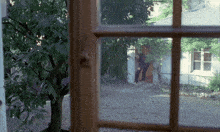 a man in a black shirt is standing in a doorway in front of a house