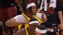 a basketball player wearing a headband and a yellow jersey with the number 114 on it