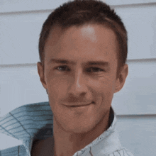 a close up of a man 's face with a white shirt on