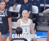 a female basketball player with the number 5 on her jersey stands on the court