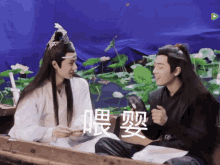 two men are sitting in a boat with chinese writing on the bottom
