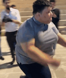 a man in a grey shirt is running in front of a crowd