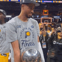 indiana pacers player holding a trophy in front of a crowd