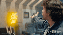a man is pointing at a sign that says ironheart on it