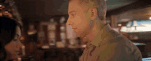 a man and woman are looking at each other in a restaurant
