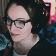 a close up of a woman wearing glasses and headphones .