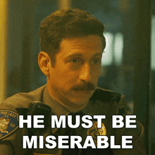 a man with a mustache says he must be miserable on a screen