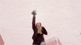 a man is standing in front of a red wheel with his fist in the air