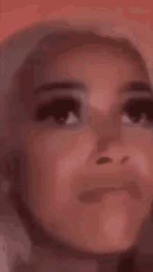 a close up of a woman 's face with a red background and a blurred background .
