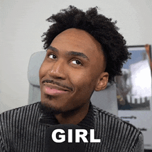 a man with a beard is wearing a striped sweater and a black microphone with the word girl written on it