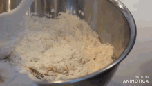 a metal bowl filled with rice and a white spoon is made in animatica