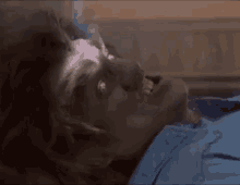 a man is laying on a bed with his eyes closed and smoke coming out of his mouth .