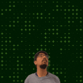 a man with glasses stands in front of a green background with the numbers 8 and 5