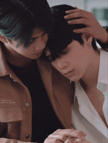 two men are hugging and one has a jacket that says ' ain ' on the front