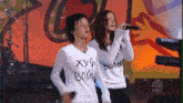 two women are singing in front of a keyboard that says virus on it