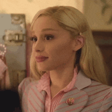 a close up of a woman wearing a pink striped suit and a pink shirt