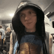 a man wearing a black hoodie and a blue shirt with a picture of a man on it .