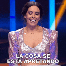 a woman in a sequined top says la cosa se esta apretando in spanish