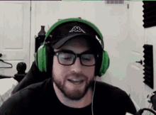 a man with a beard wearing headphones and a hat .