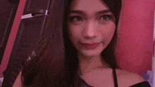 a woman in a black off the shoulder top is smiling for the camera