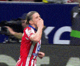 a soccer player wearing a red and white jersey with the letter m on the sleeve