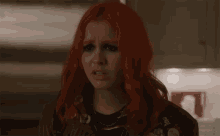 a woman with red hair and a jacket that says ' i love you '