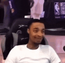 a man is sitting in a chair and smiling .