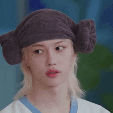 a close up of a person wearing a hat with a towel wrapped around their head .
