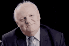 a man in a suit and tie is making a face .