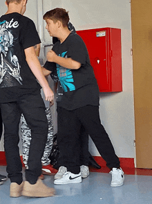 a boy wearing a black shirt that says ' arte ' on the back of it