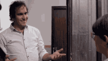 a man in a white shirt is talking to a woman