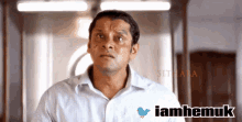 a man in a white shirt with a blue bird and the words iamhemuk below him